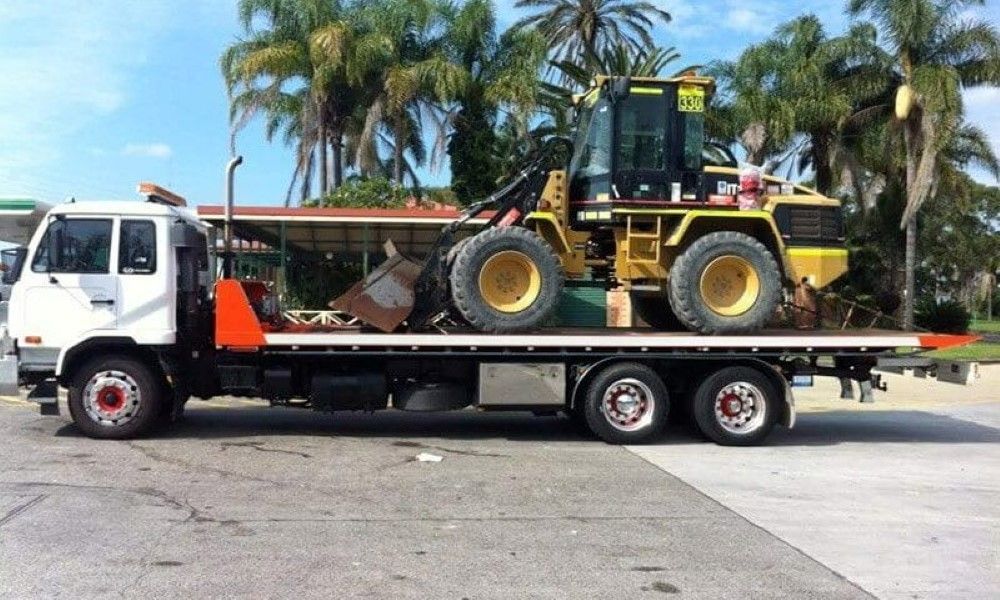 A Tow Truck with A Bulldozer on The Back of It — Easylift Towing NSW Pty Ltd In Marks Point, QLD