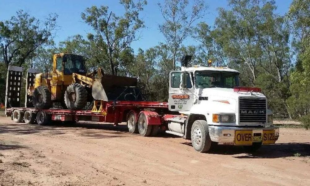 A Mack Truck Is Carrying a Bulldozer on A Trailer — Easylift Towing NSW Pty Ltd In Marks Point, QLD