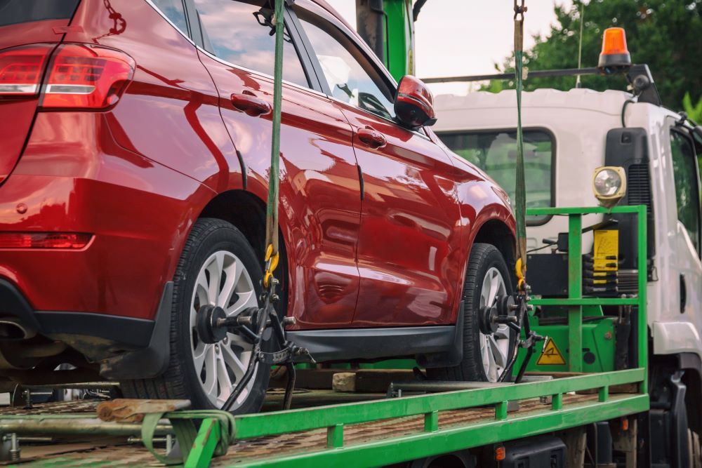 A Red Car Is Being Towed by A Tow Truck — Easylift Towing NSW Pty Ltd In Catherine Hill Bay, QLD