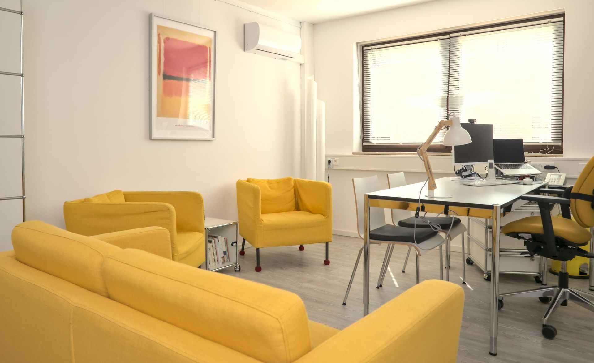 Sprechzimmer mit gelber Couch und zwei gelben Sesseln, Schreibtisch, Computer