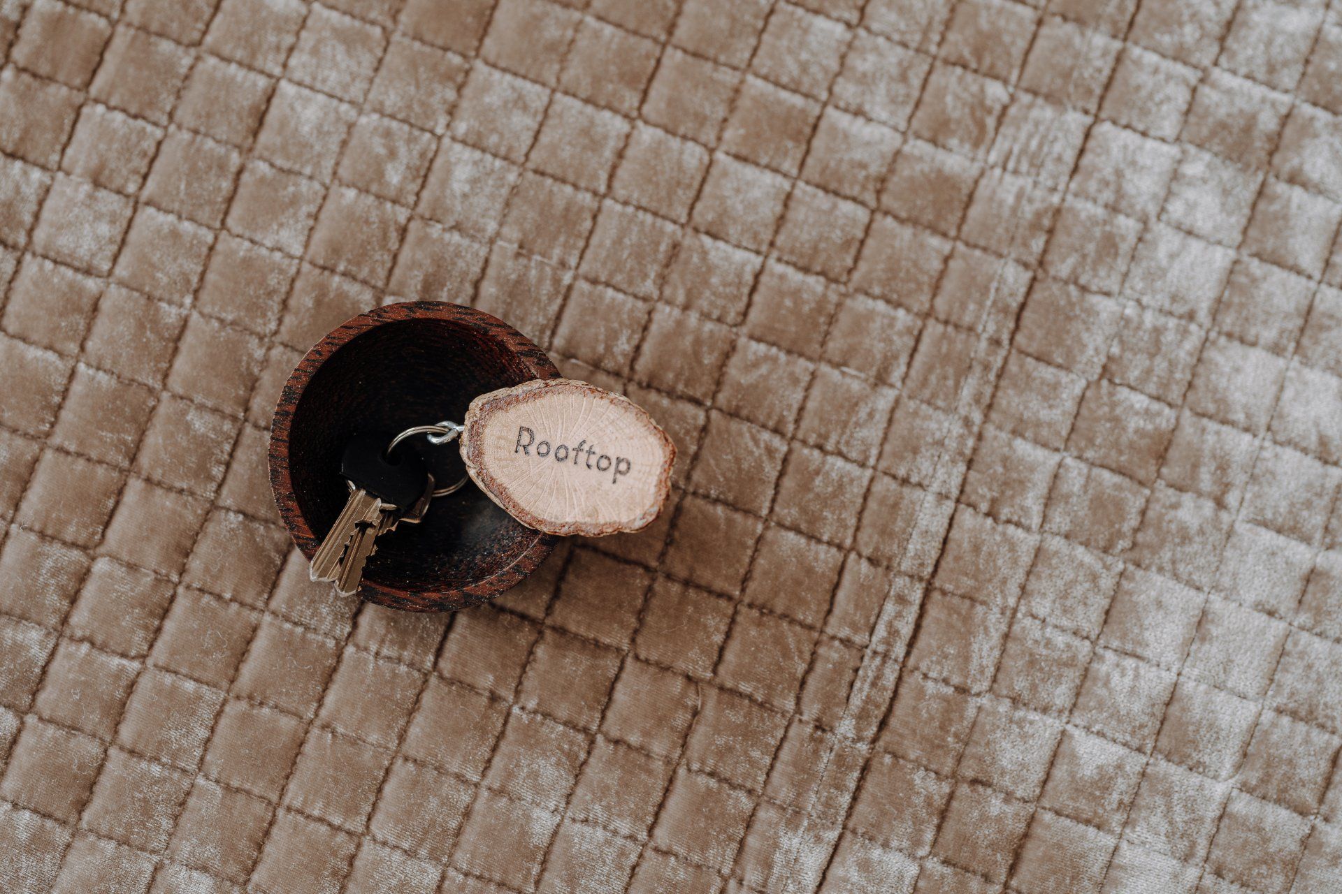 Sleutels en een houten sleutelhangertje met de tekst 