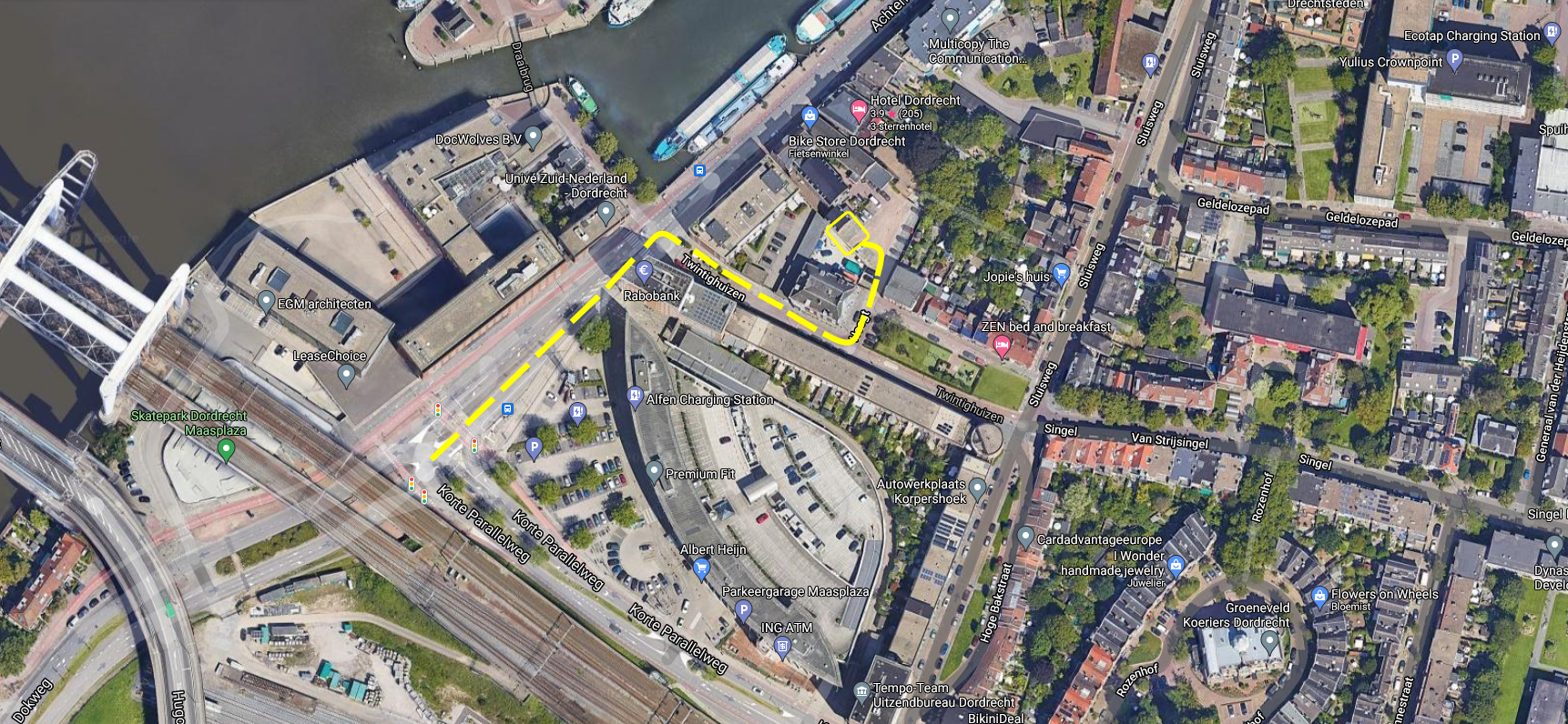 Luchtfoto van gebouwen, wegen en waterwegen; een gele omlijning geeft een gebied aan.