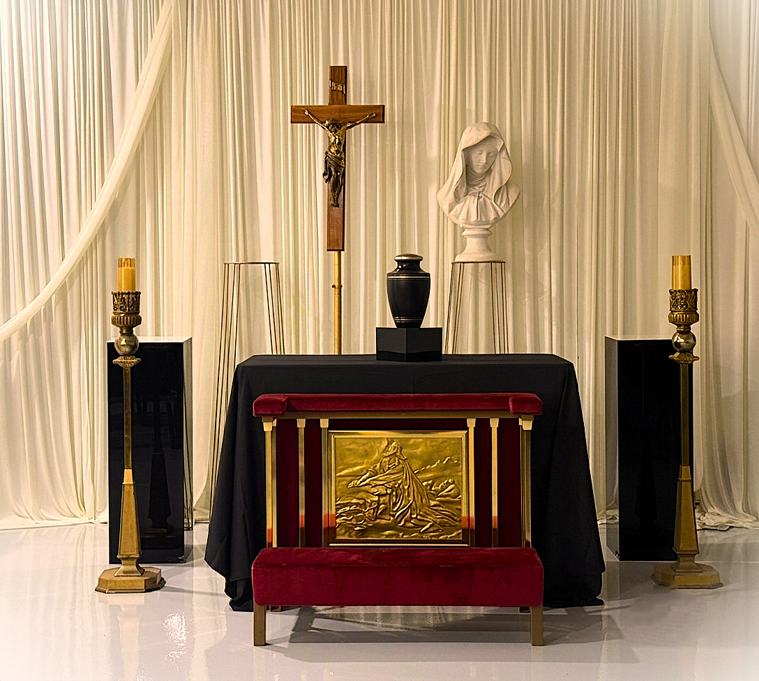 Catholic altar with crucifix, candles, and gold tabernacle draped in cream curtains