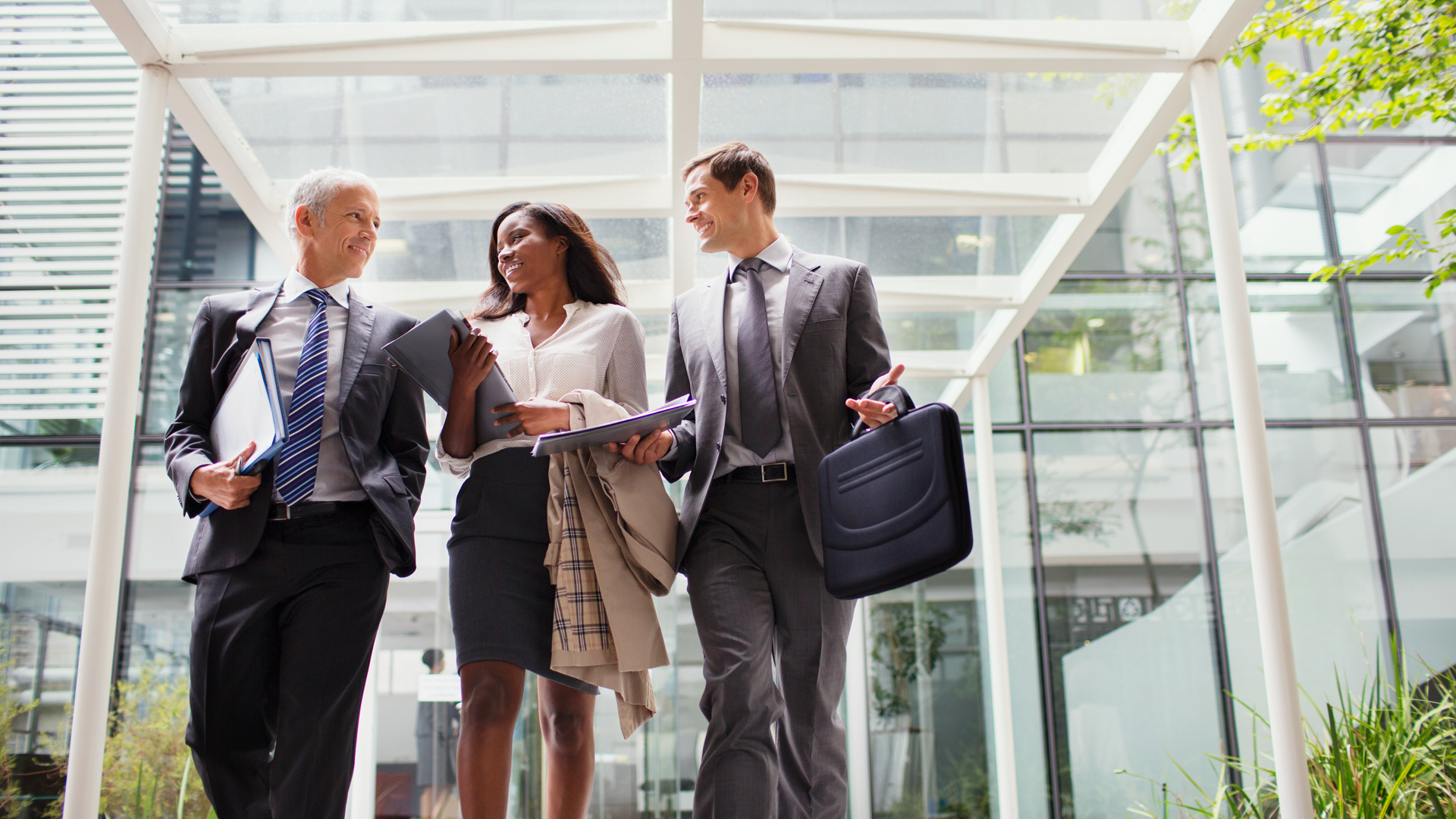 A group of business people are walking in front of a building.
