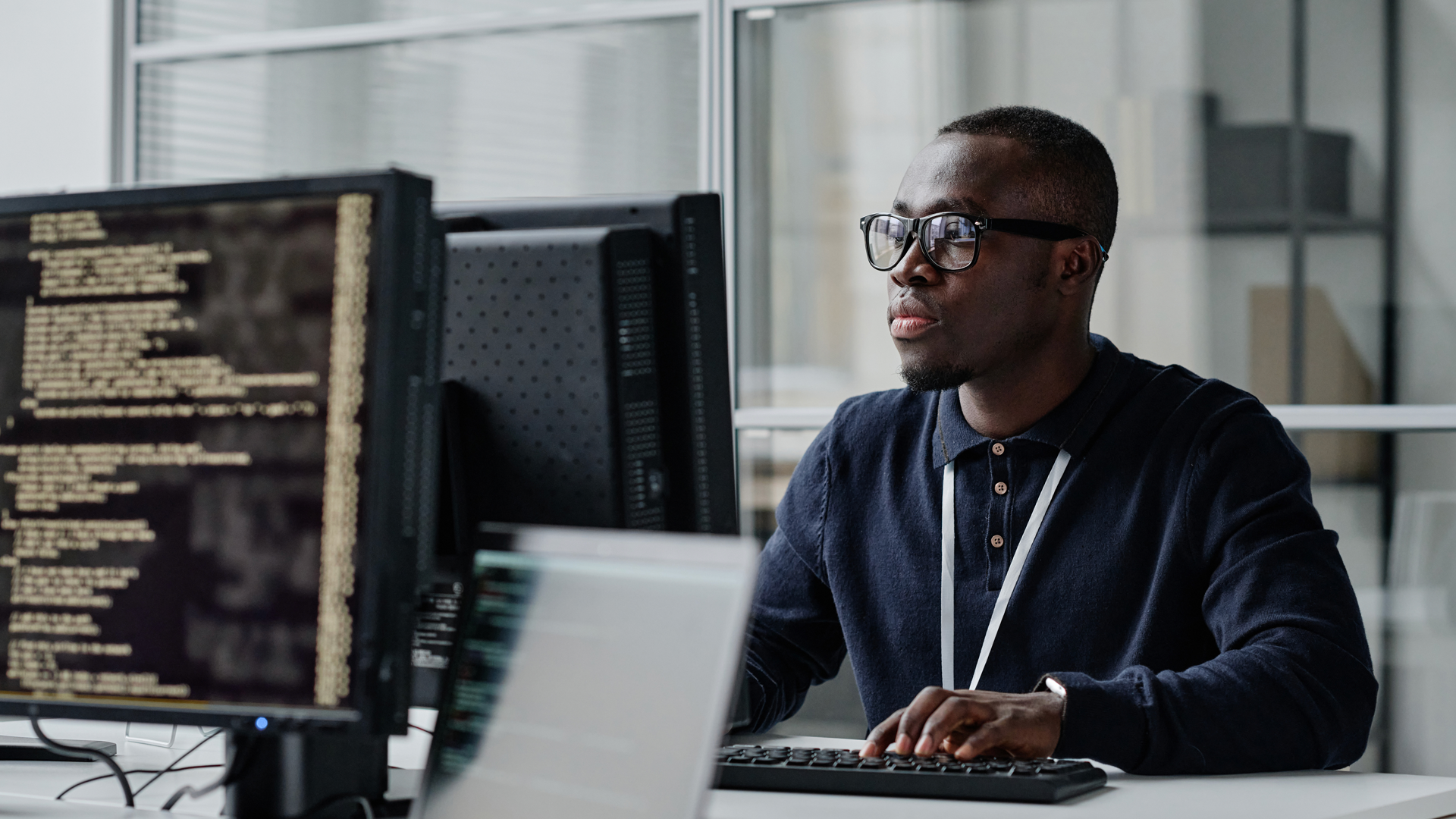 A man is sitting at a desk in front of a computer.