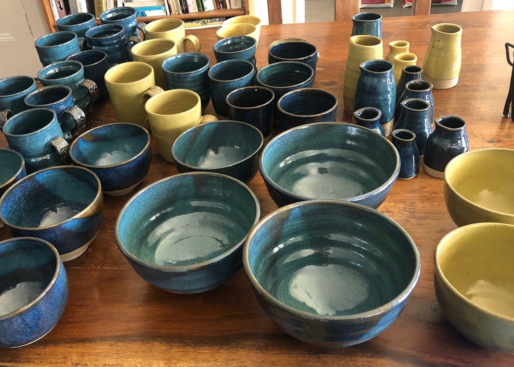 A table topped with a variety of bowls and mugs.