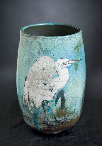 A blue vase with a bird painted on it