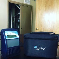 A bag and a device are sitting on a table in a room.