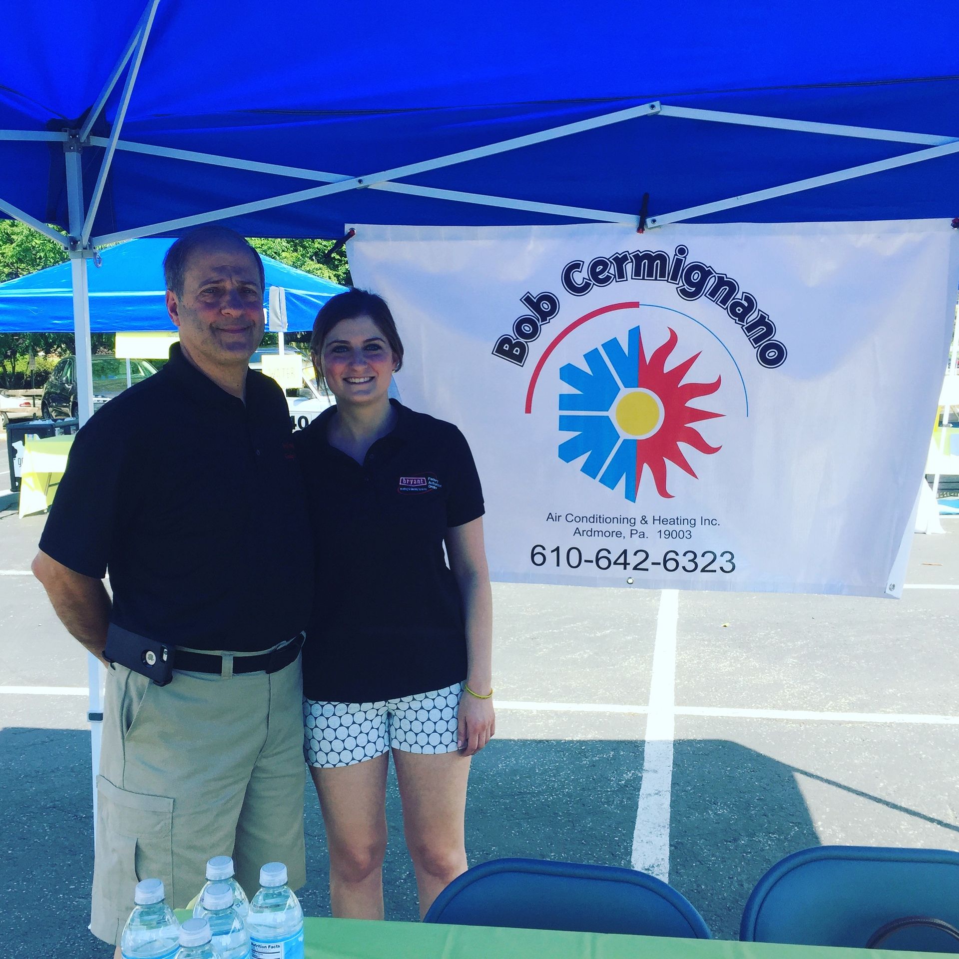 A man and a woman standing in front of a bob cermignano banner