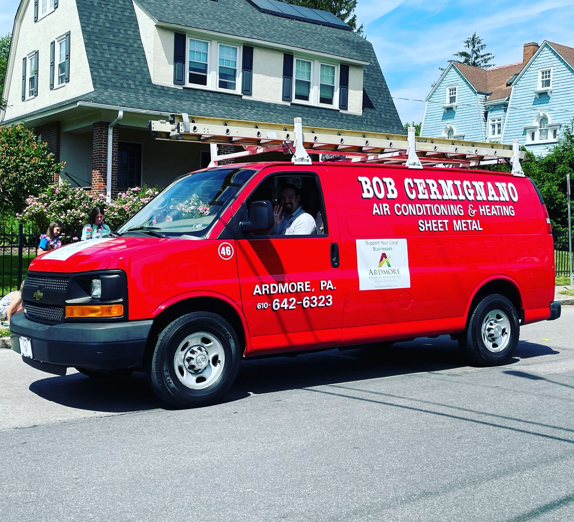 A red van is parked in front of a house