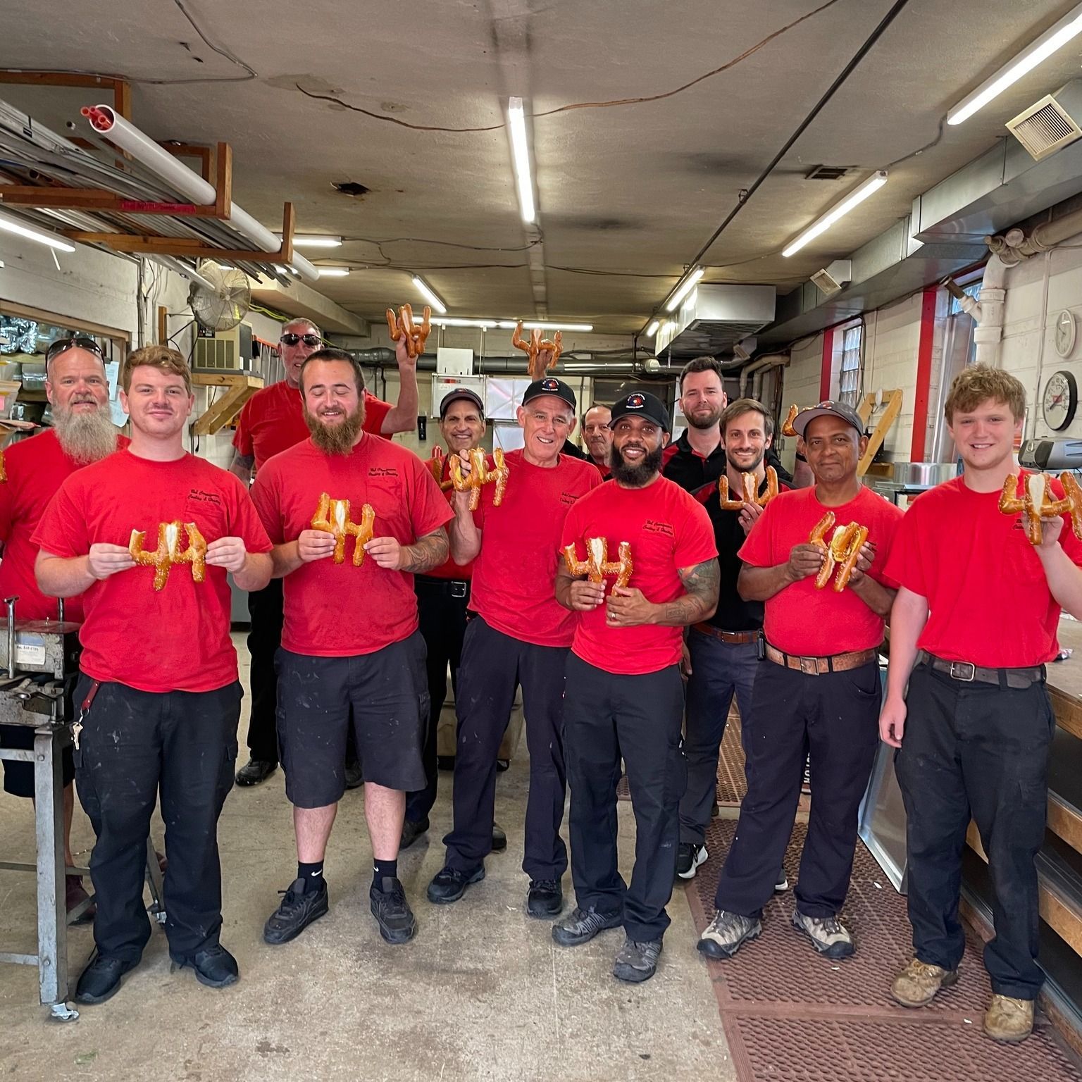A group of men in red shirts are holding french fries