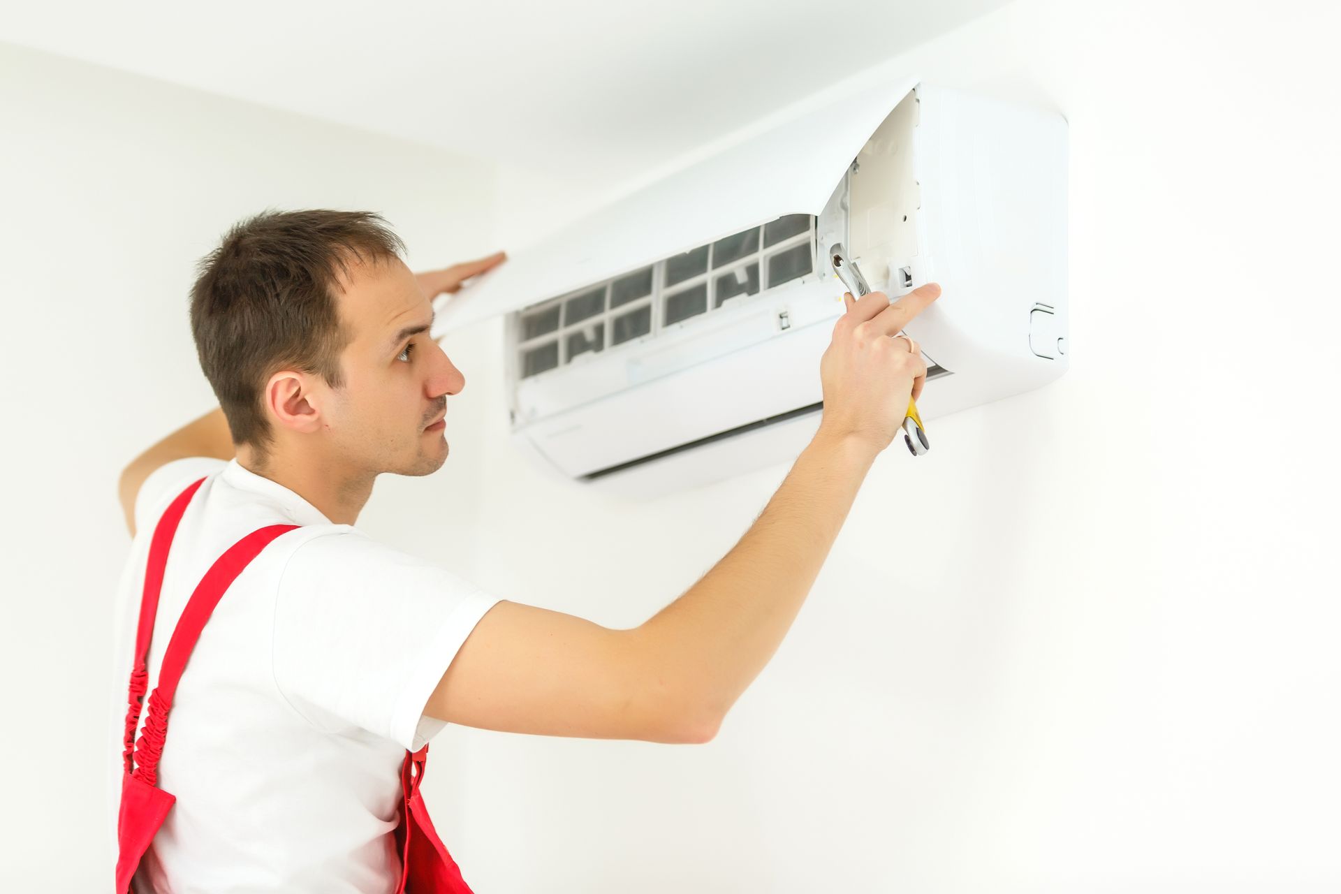 Worker repairing air conditioner in the room.