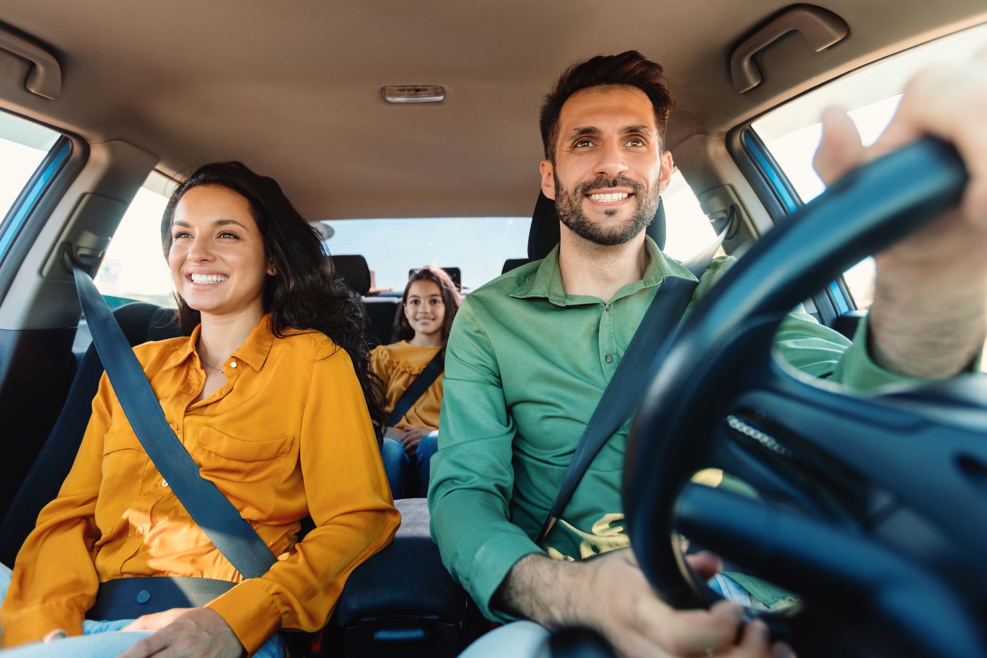 Family riding together in a car with seatbelts on during a safe and comfortable drive.