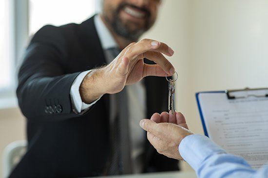 Giving Keys to New House Owner — Lincoln, NE — Advantage Insurance Agency A man helping new homeowners with home insurance in Lincoln, NE