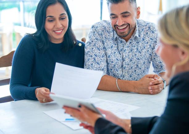 A couple examines a homeowners insurance document details together at a table.