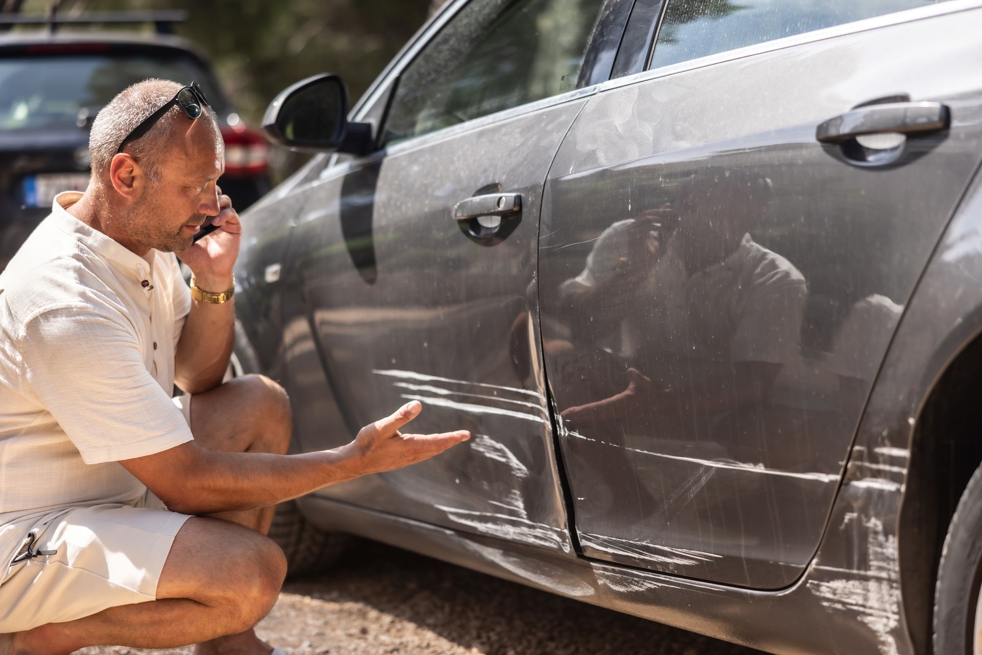 A man calls the insurance company because someone backed into the side door of his car.