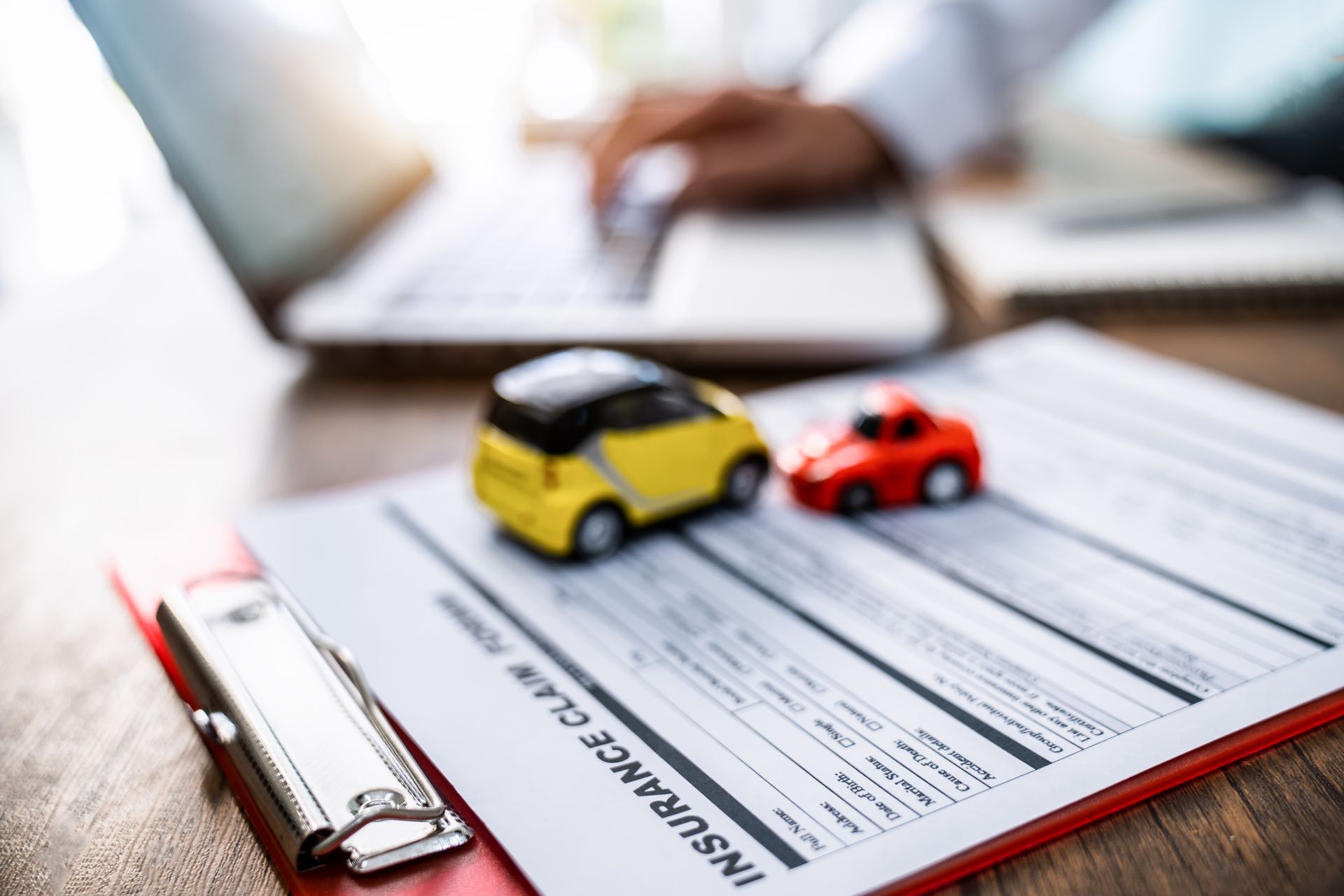 Toy cars over an insurance claim on a desk.