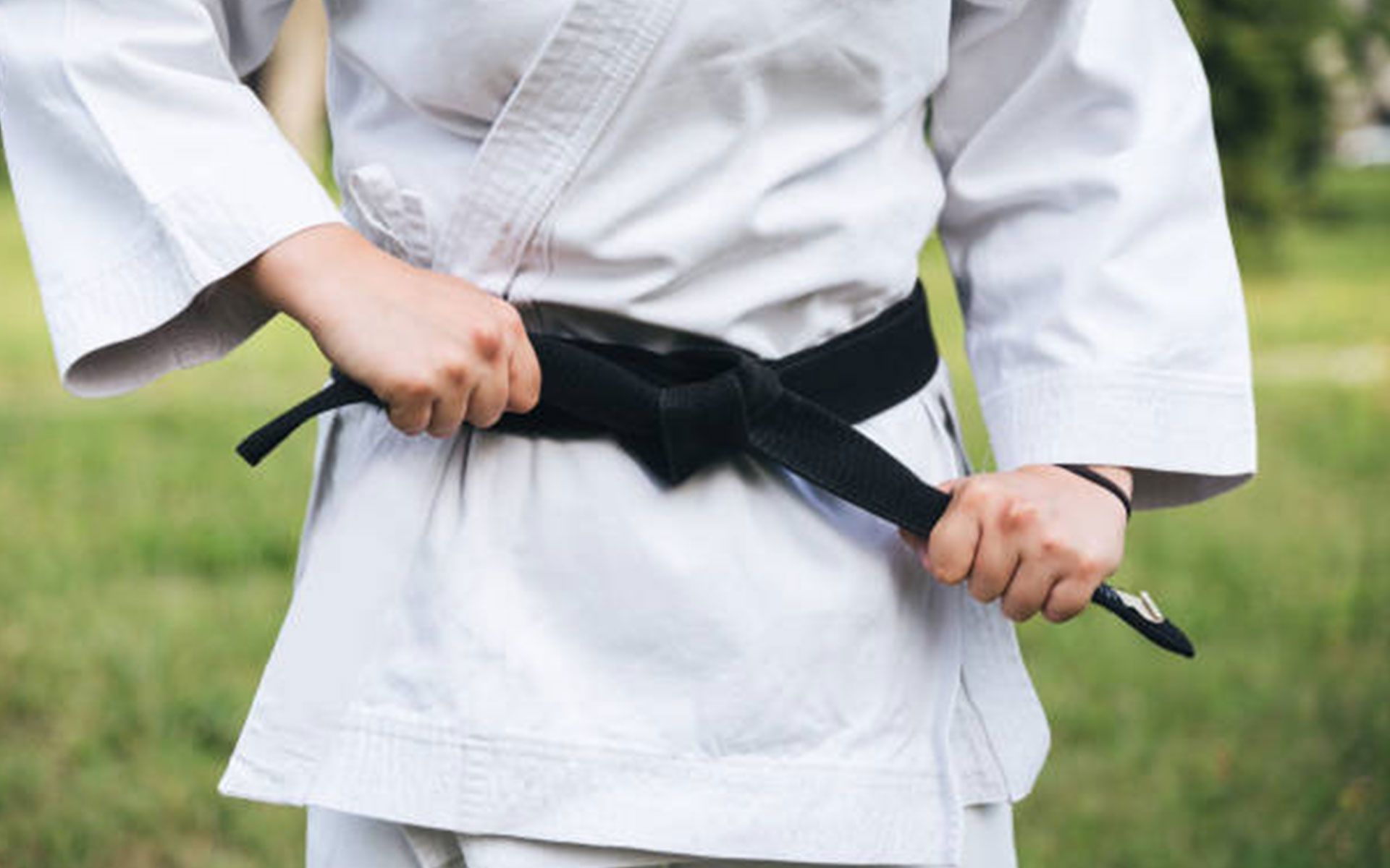 Two young boys are practicing martial arts in a gym.