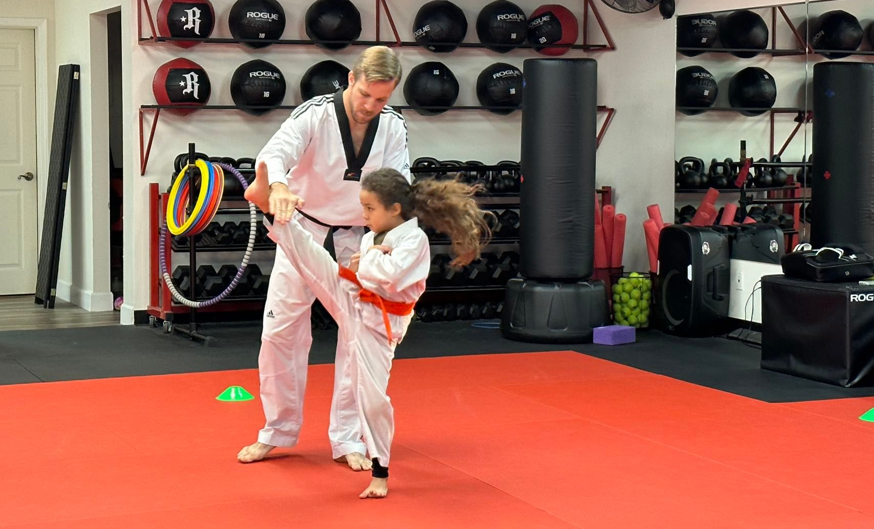 Two young boys are practicing martial arts in a gym.