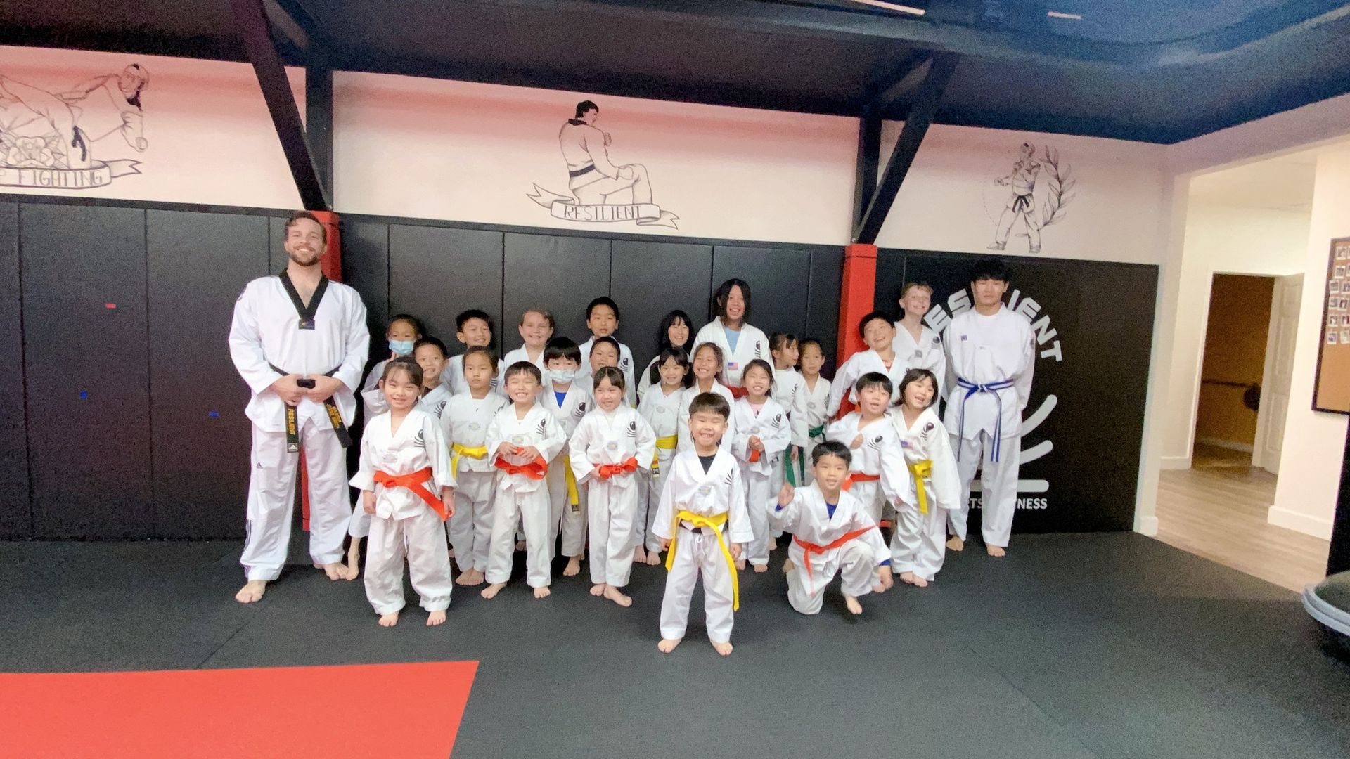 A group of children are posing for a picture in a gym.