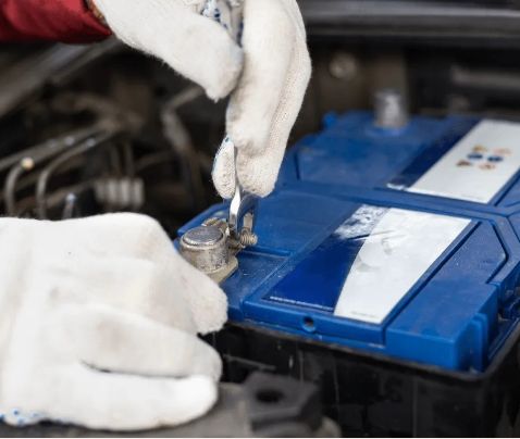 Mechanic tightening car battery terminal with wrench