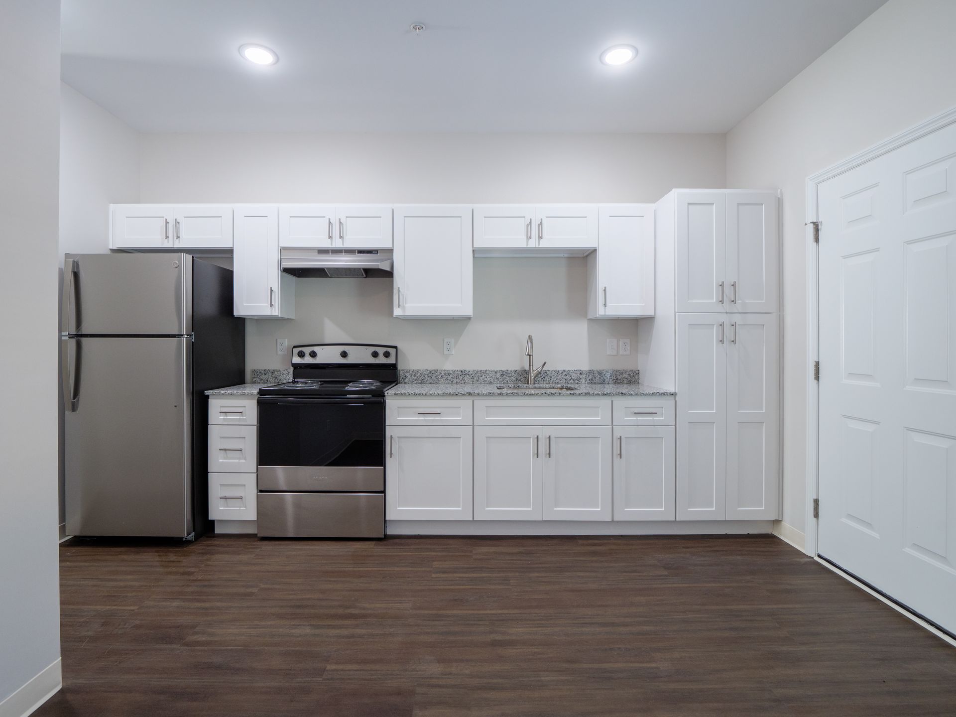 Modern kitchen with granite countertops and white shaker cabinets
