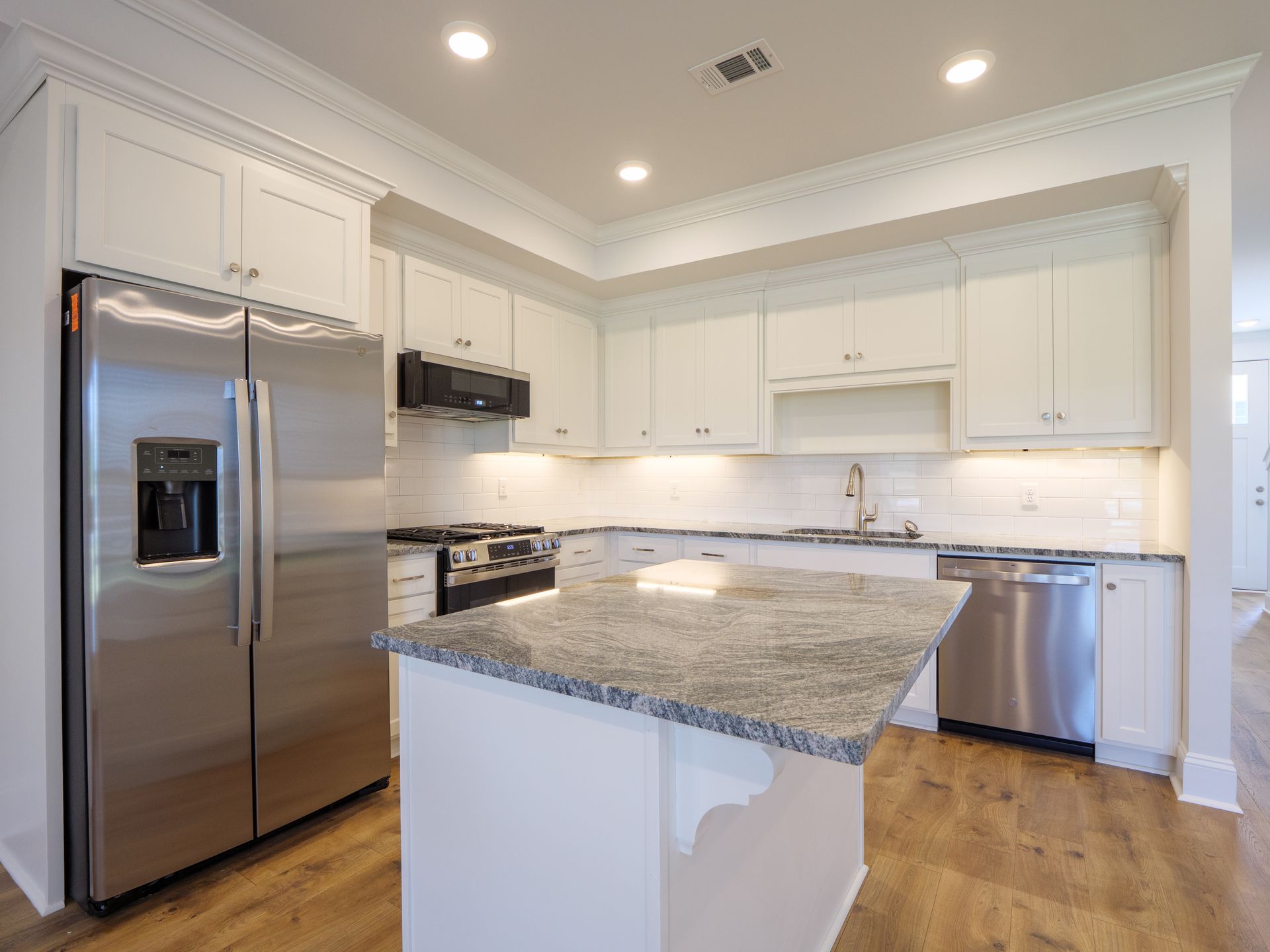 Photorealistic modern luxury townhome kitchen with granite countertops, stainless steel appliances, and a large island
