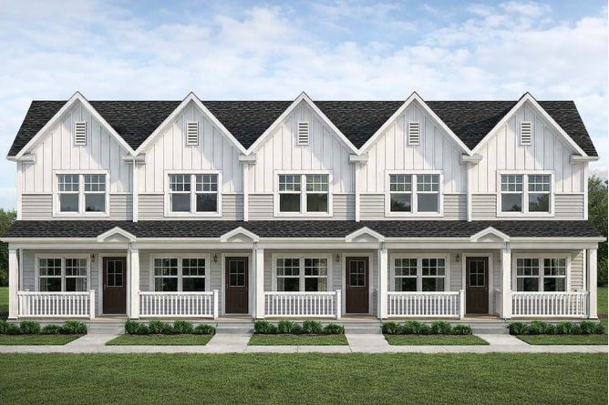 Row of white townhouses with gray roofs and front porches under a blue sky