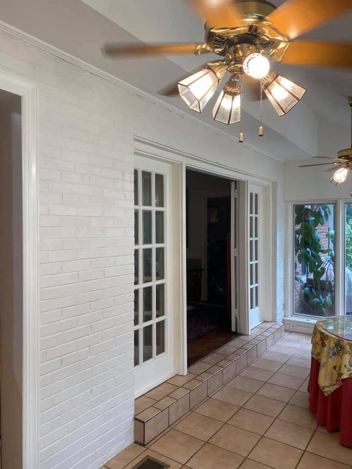 Covered patio with white brick walls, tiled floor, sliding glass door, and ceiling fan lights Covered patio with white brick walls, tiled floor, sliding glass door, and ceiling fan lights