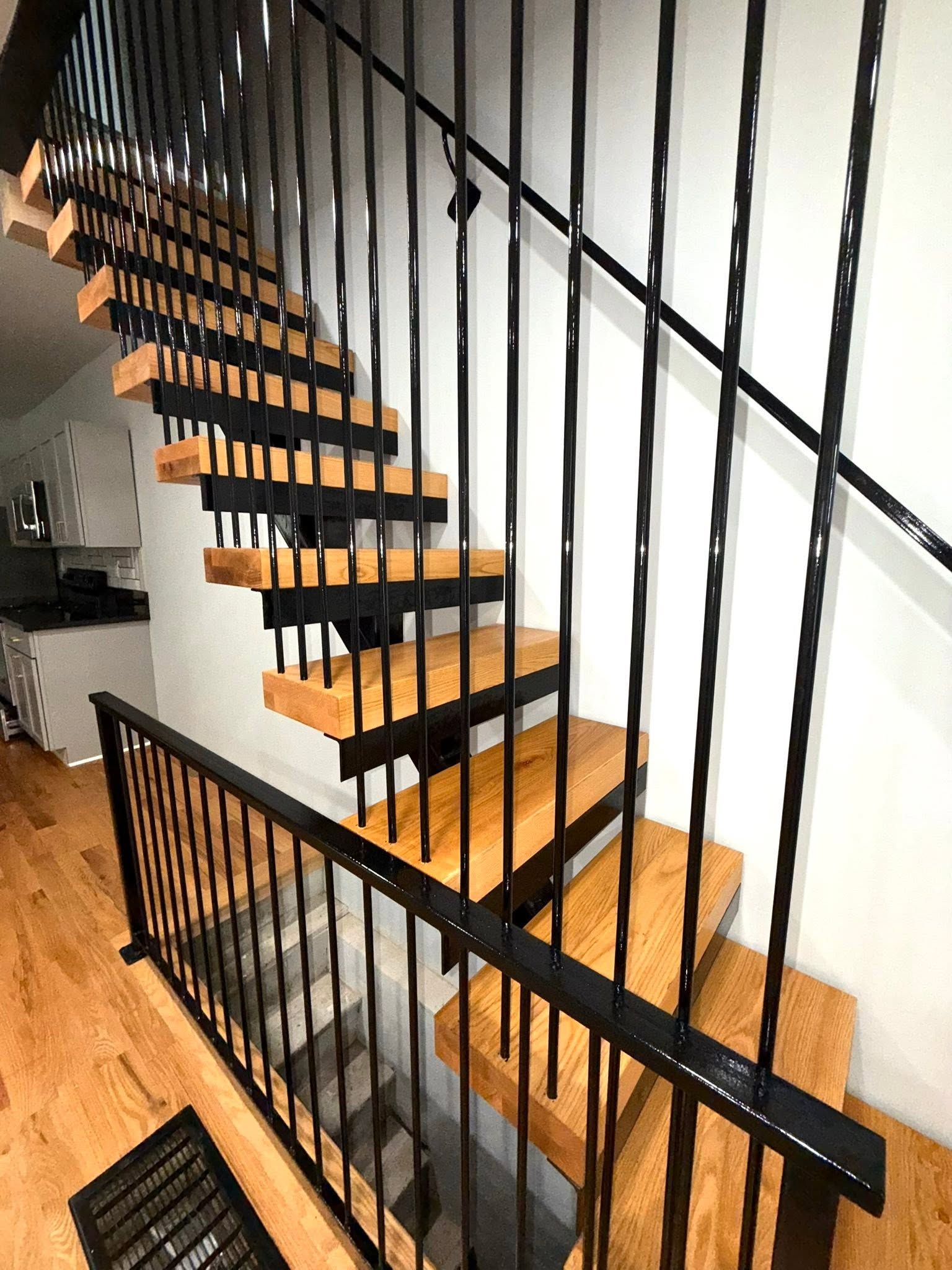 Modern indoor staircase with black railings and wooden steps in a bright hallway Modern indoor staircase with black railings and wooden steps in a bright hallway
