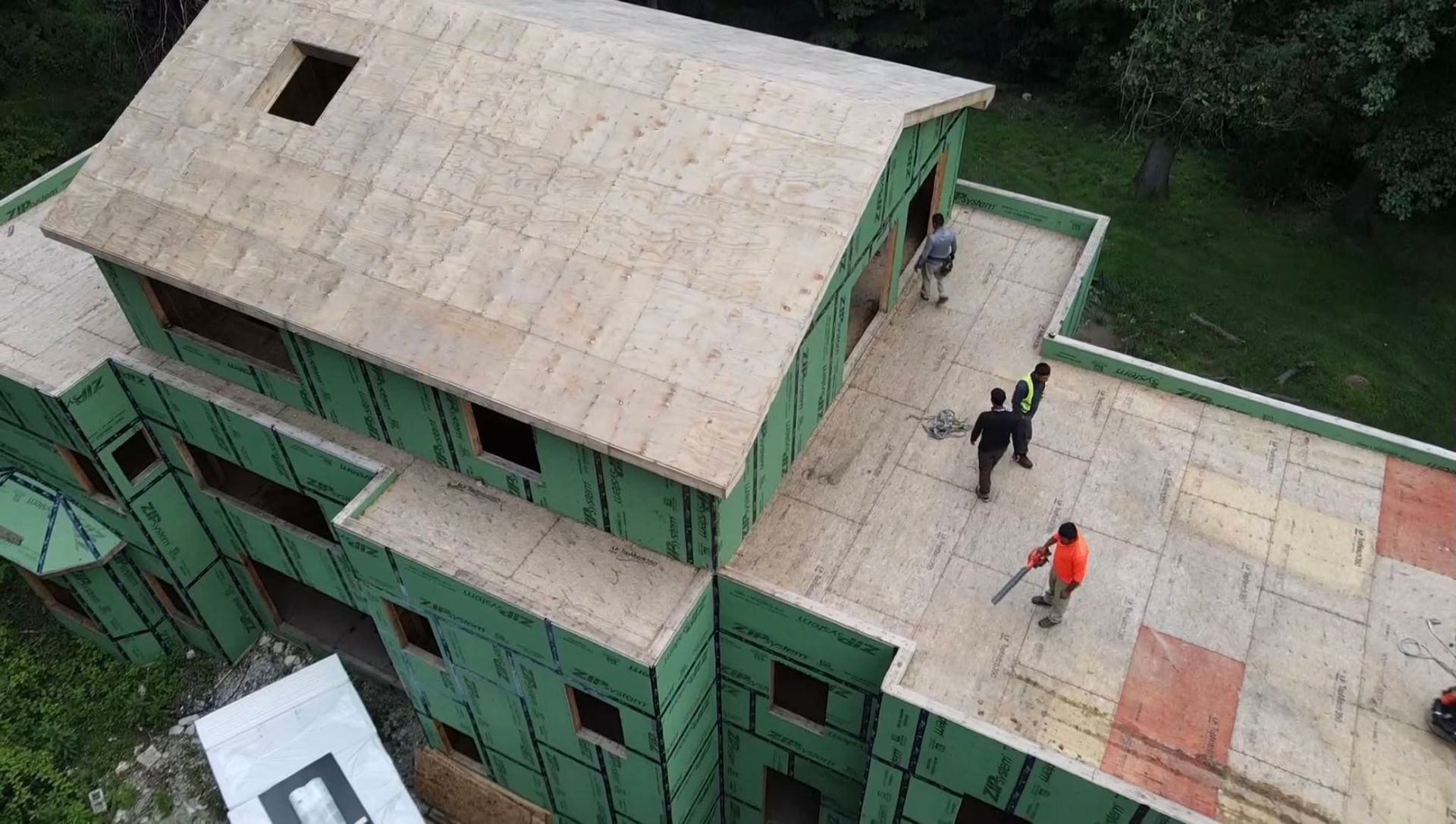 Workers on a green building rooftop under construction, seen from above. Workers on a green building rooftop under construction, seen from above.