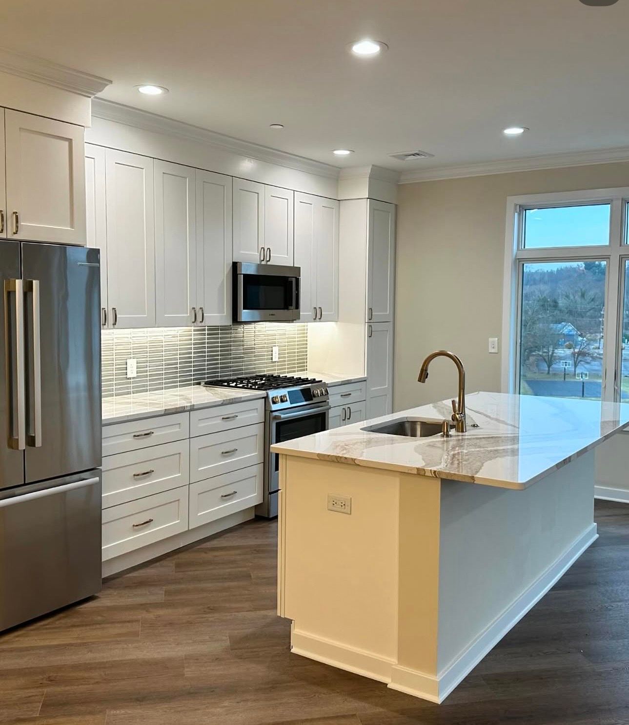Modern kitchen with black cabinets, stainless dishwasher, open shelves, and a window with blinds Modern kitchen with black cabinets, stainless dishwasher, open shelves, and a window with blinds