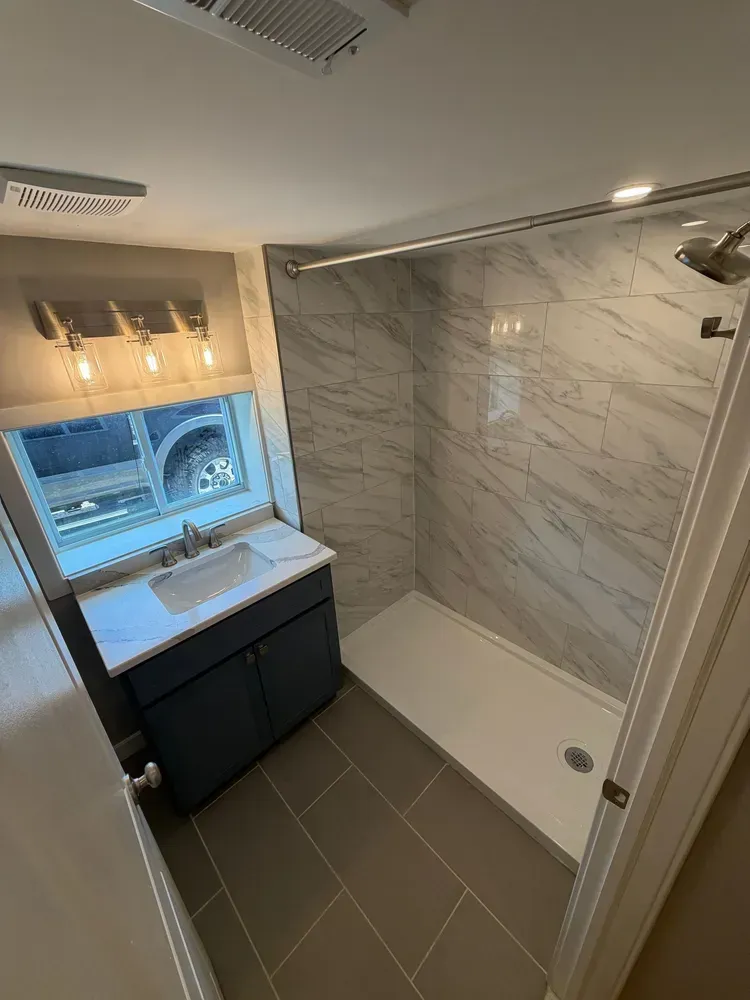 Small bathroom with walk-in shower, vanity sink, and tiled floor