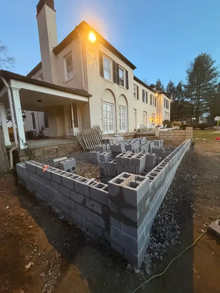 Partially built house with cinder block foundation under construction at dusk