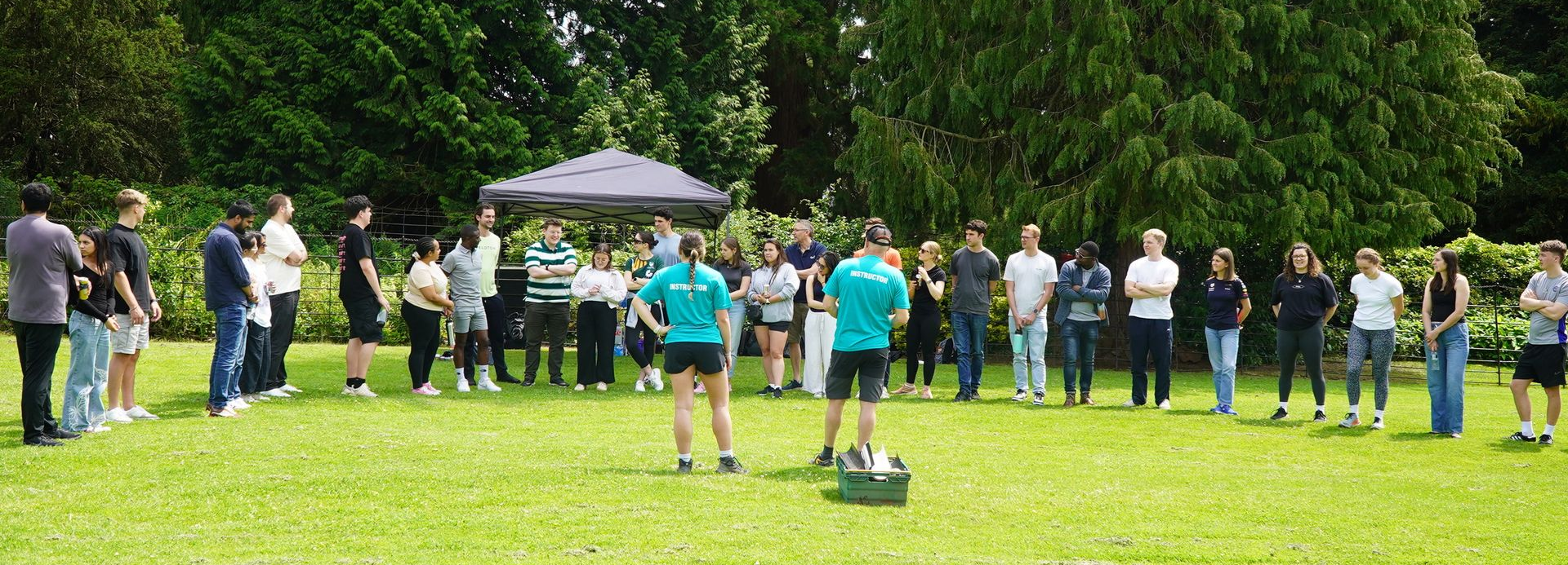 Corporate team being introduced to their outdoor team building day by two instructors outdoor activities near me