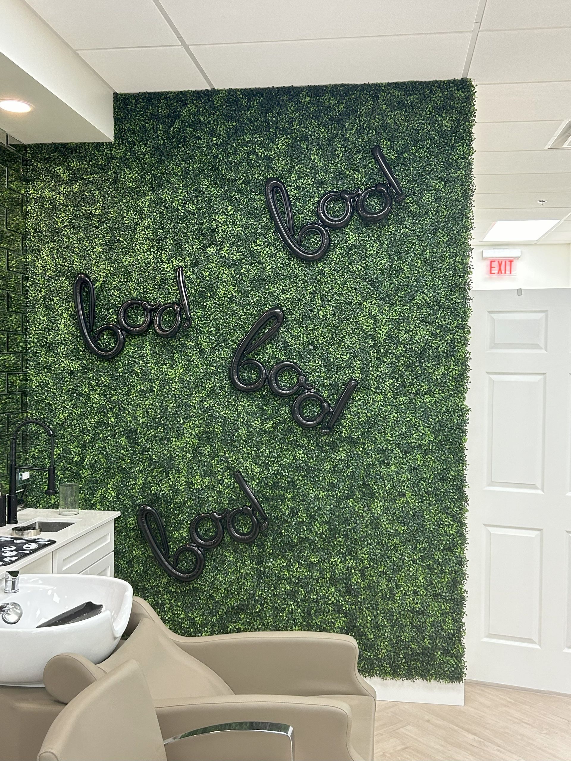 A hair salon with a green wall and a sink.