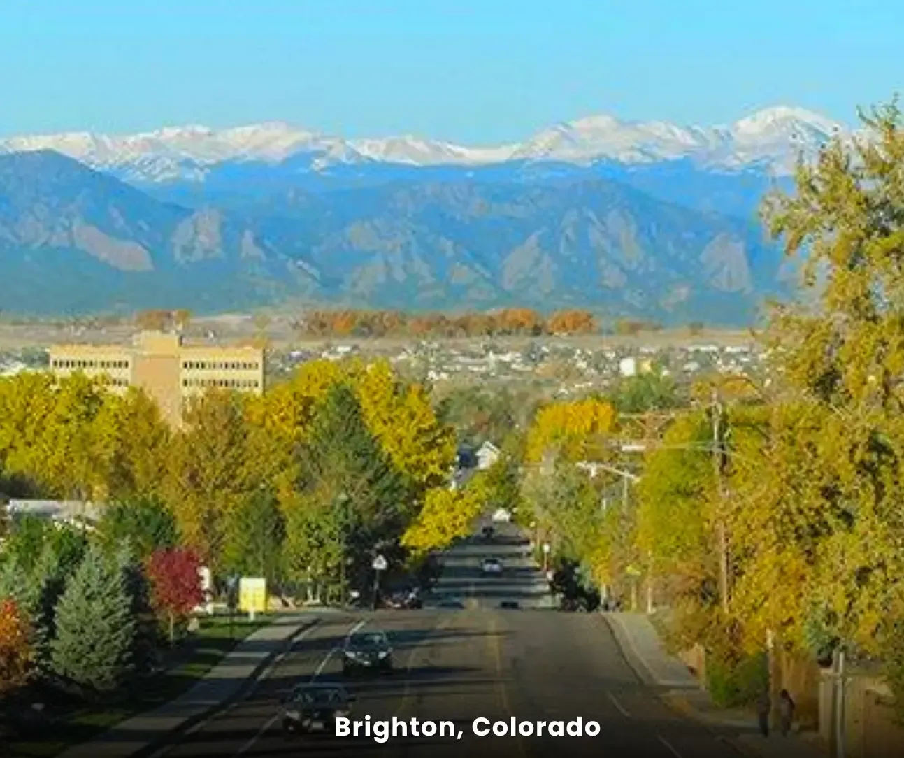 Brighton, Colorado city view with tree-lined street and mountain backdrop, service area for professional tile cleaning