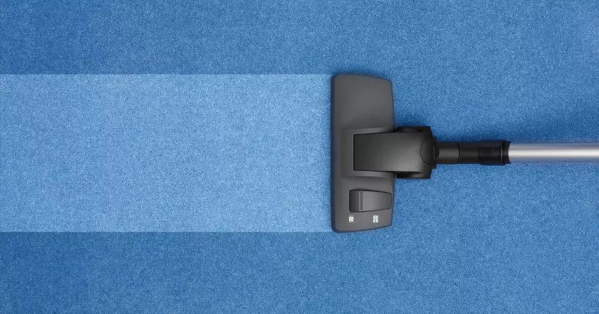 A vacuum cleaner on a blue carpet
