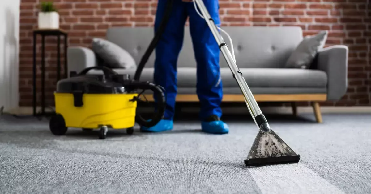A person vacuuming carpet with a vacuum cleaner