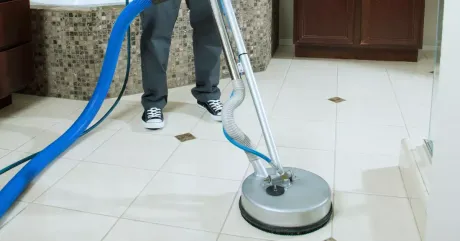 Tile cleaning service in progress as a technician uses a professional rotary floor machine to deep clean bathroom tile