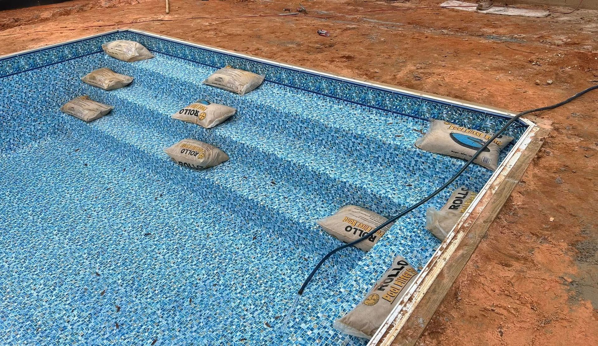 A swimming pool is being built in the dirt.