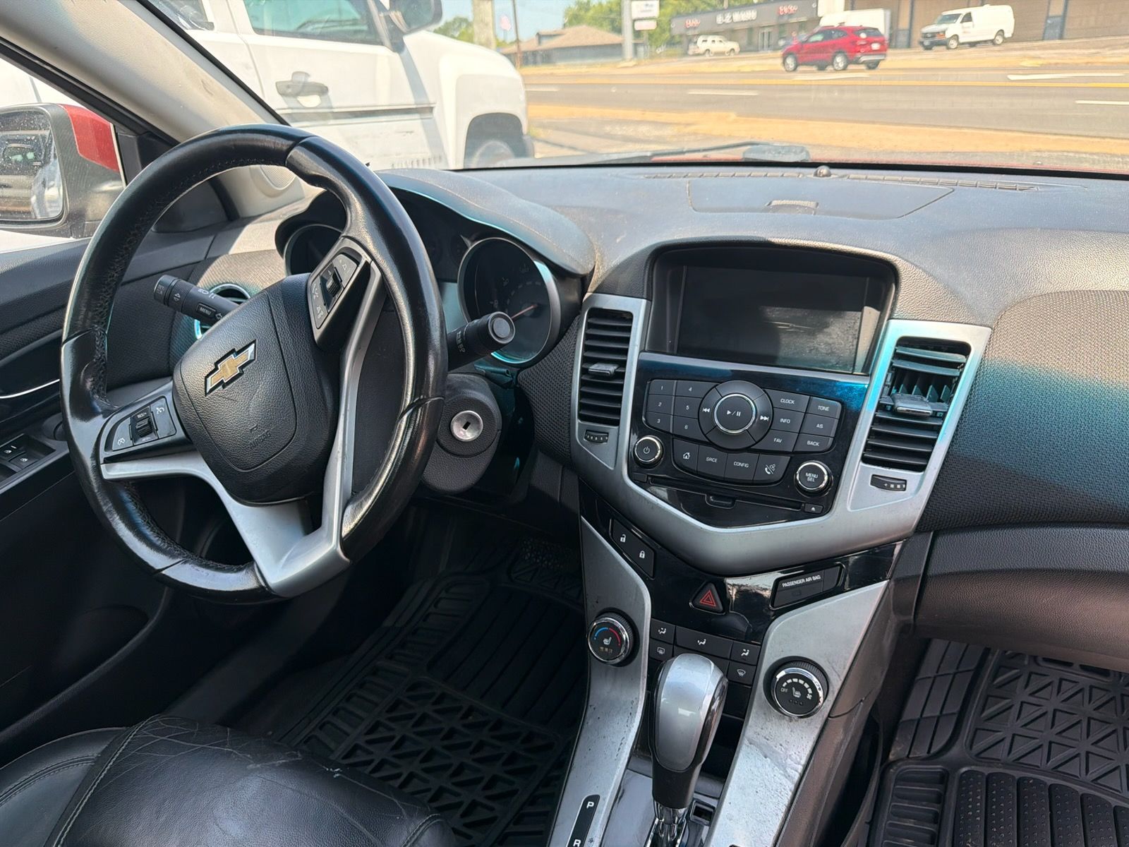 Interior of a Chevrolet car showing the steering wheel, dashboard, center console, and gear shift