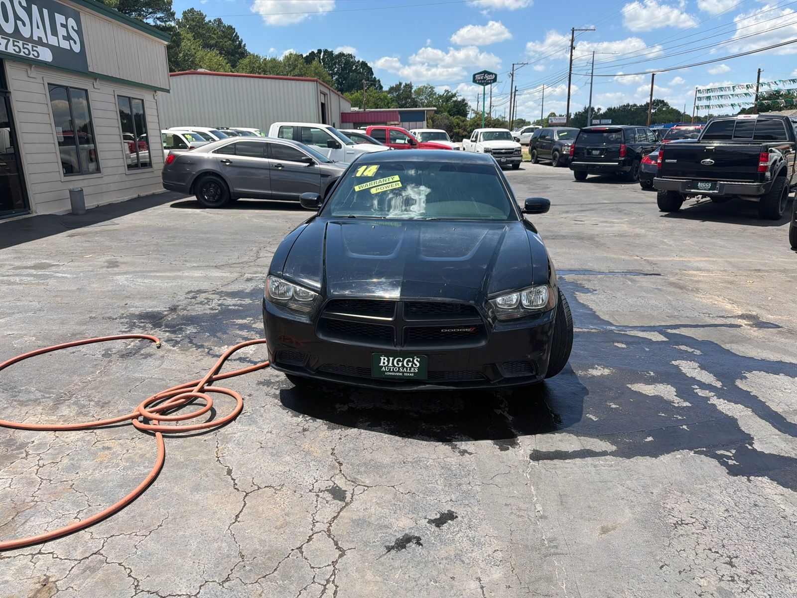 Black sedan parked on a car lot with a price marked on the windshield.