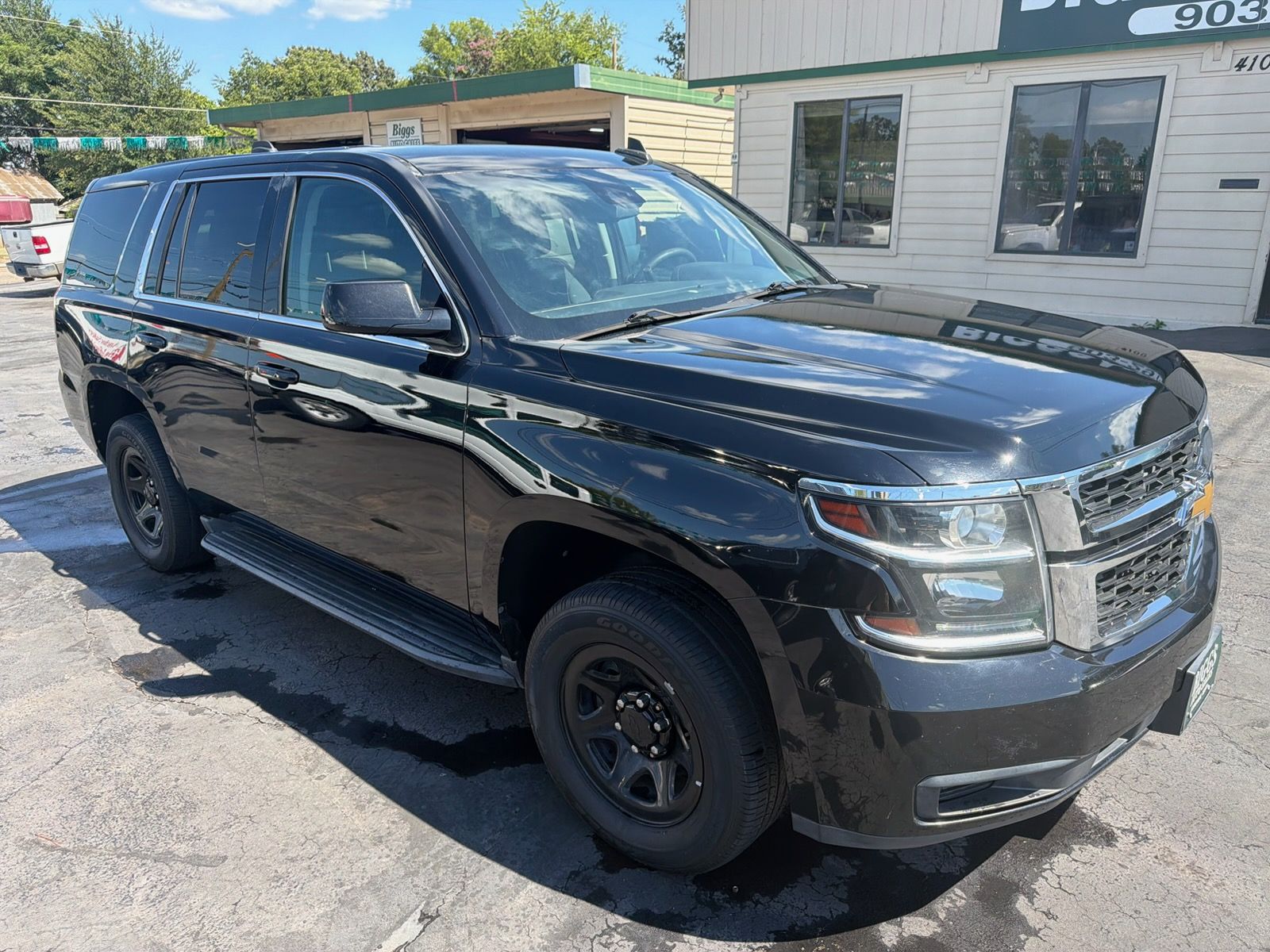Black SUV parked outside a building in daylight