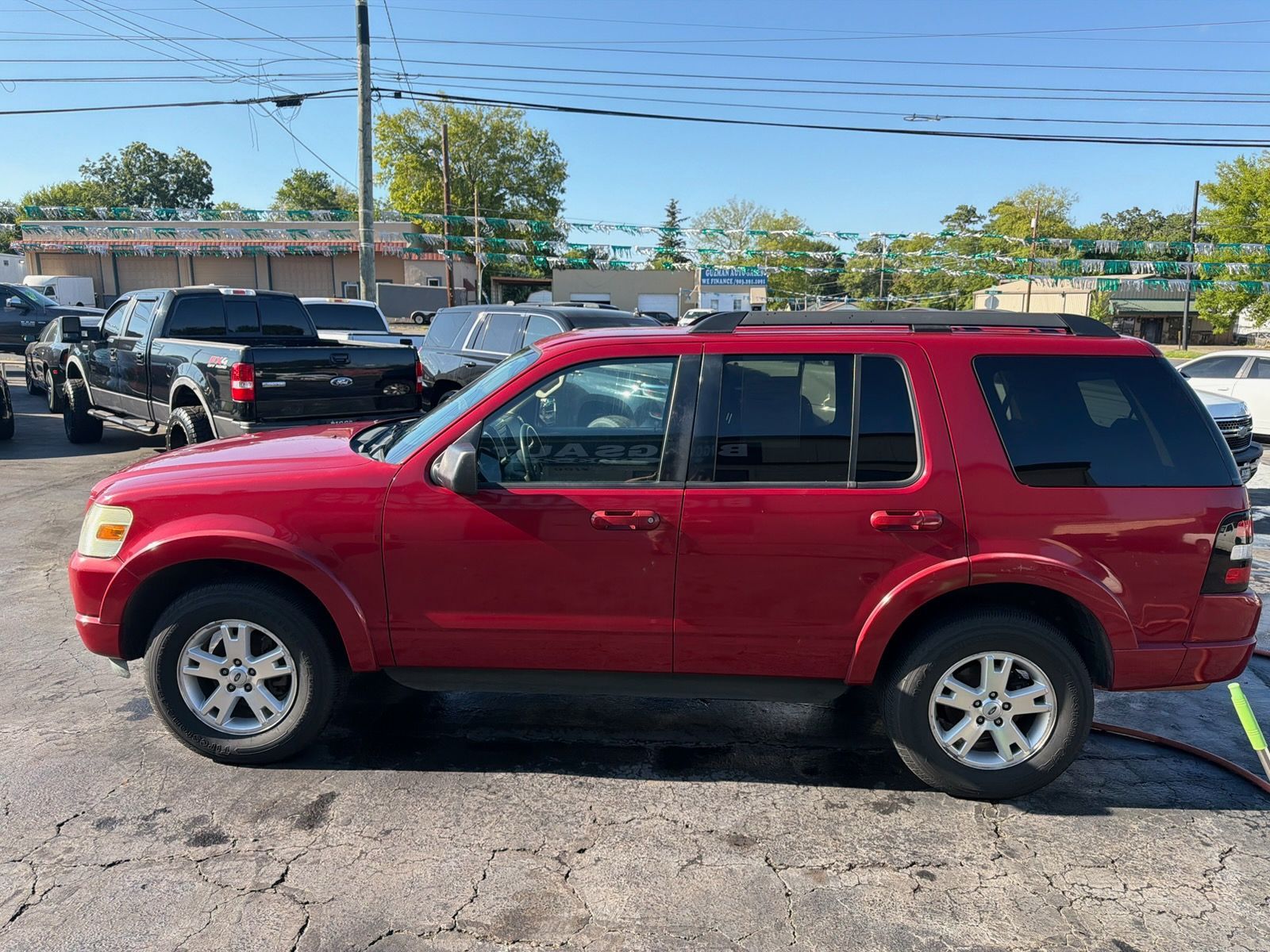 Red SUV parked in a lot on a sunny day, side view.