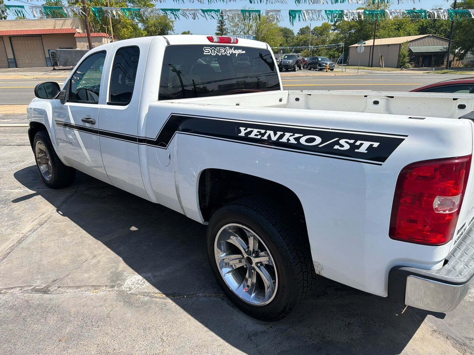 White pickup truck with “Yenlo Street” decal parked in a sunny lot
