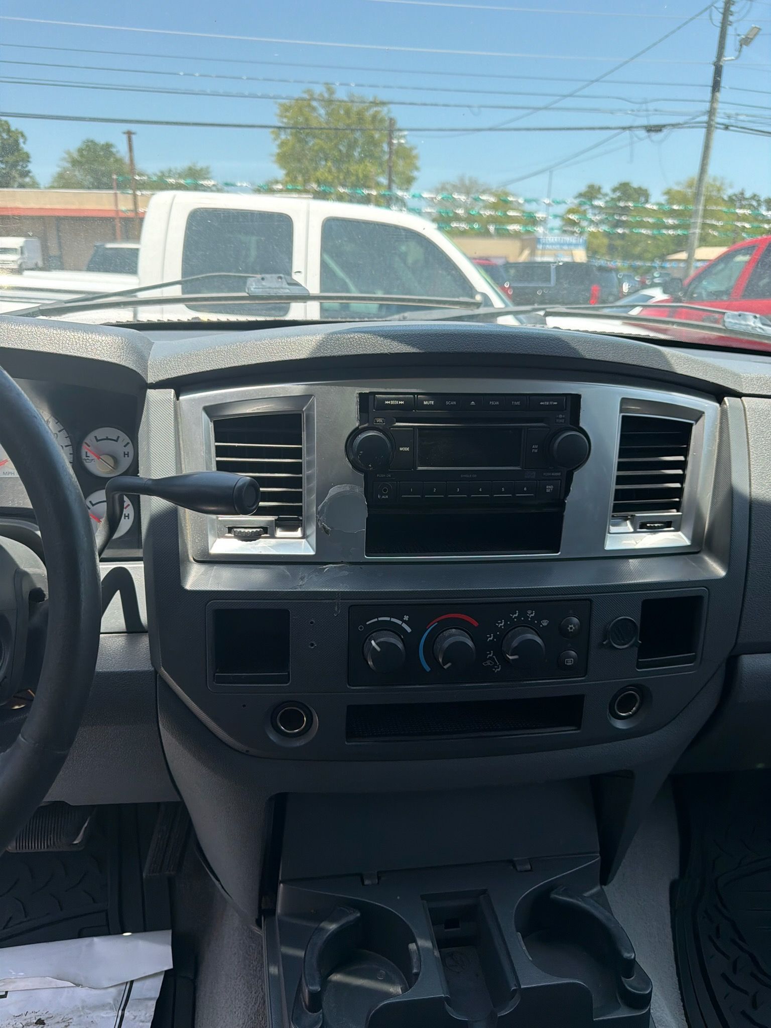 Car dashboard and center console with radio and vents, viewed from the driver’s seat inside a vehicle.