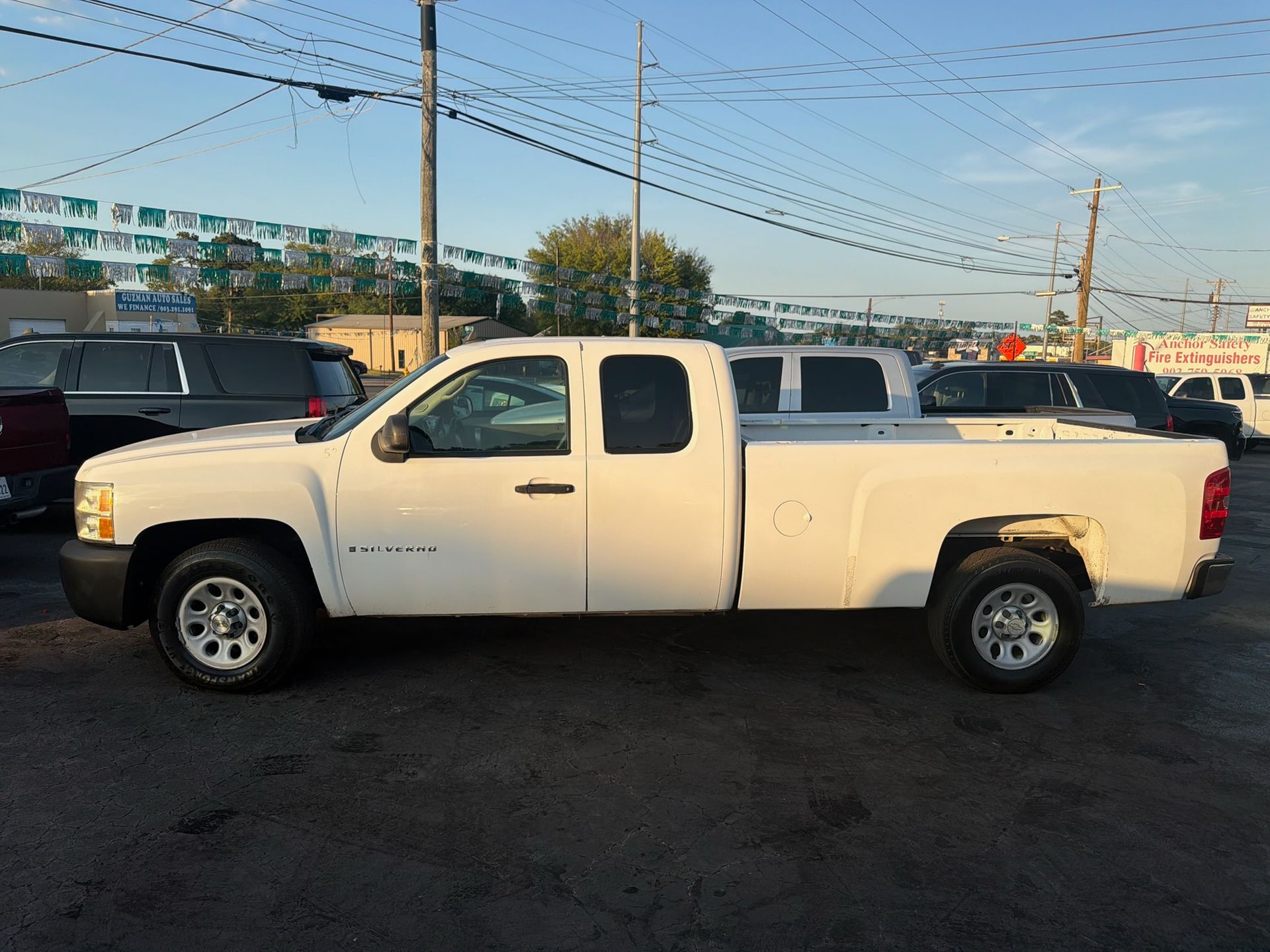 White extended-cab pickup truck parked on a lot under a clear sky