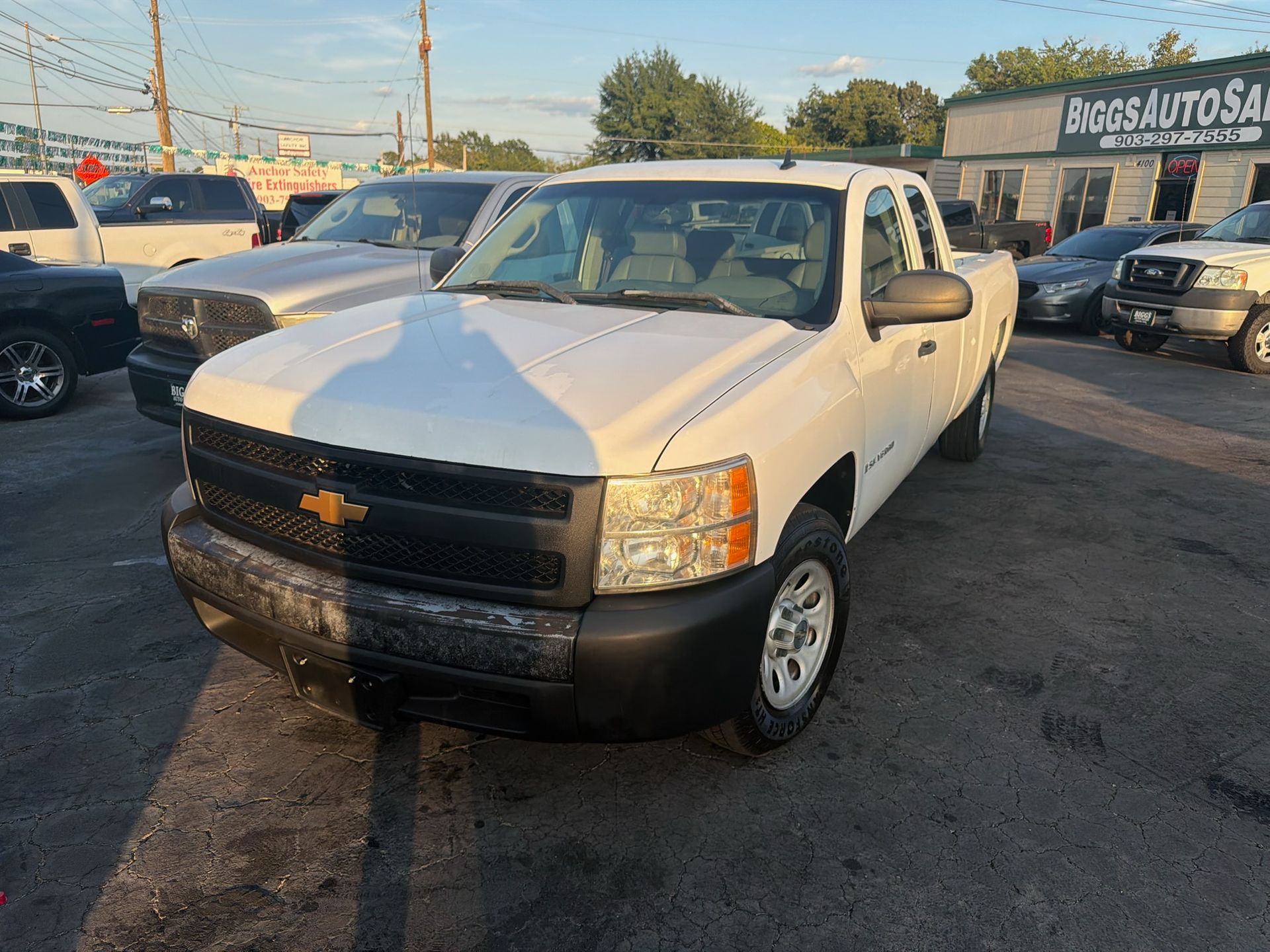 White Chevrolet pickup truck parked on a car lot at dusk