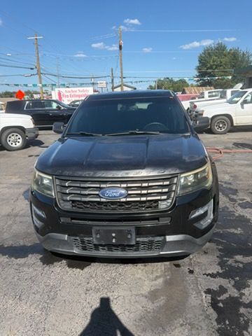 Black Ford SUV parked front-facing on a car lot under a clear sky.